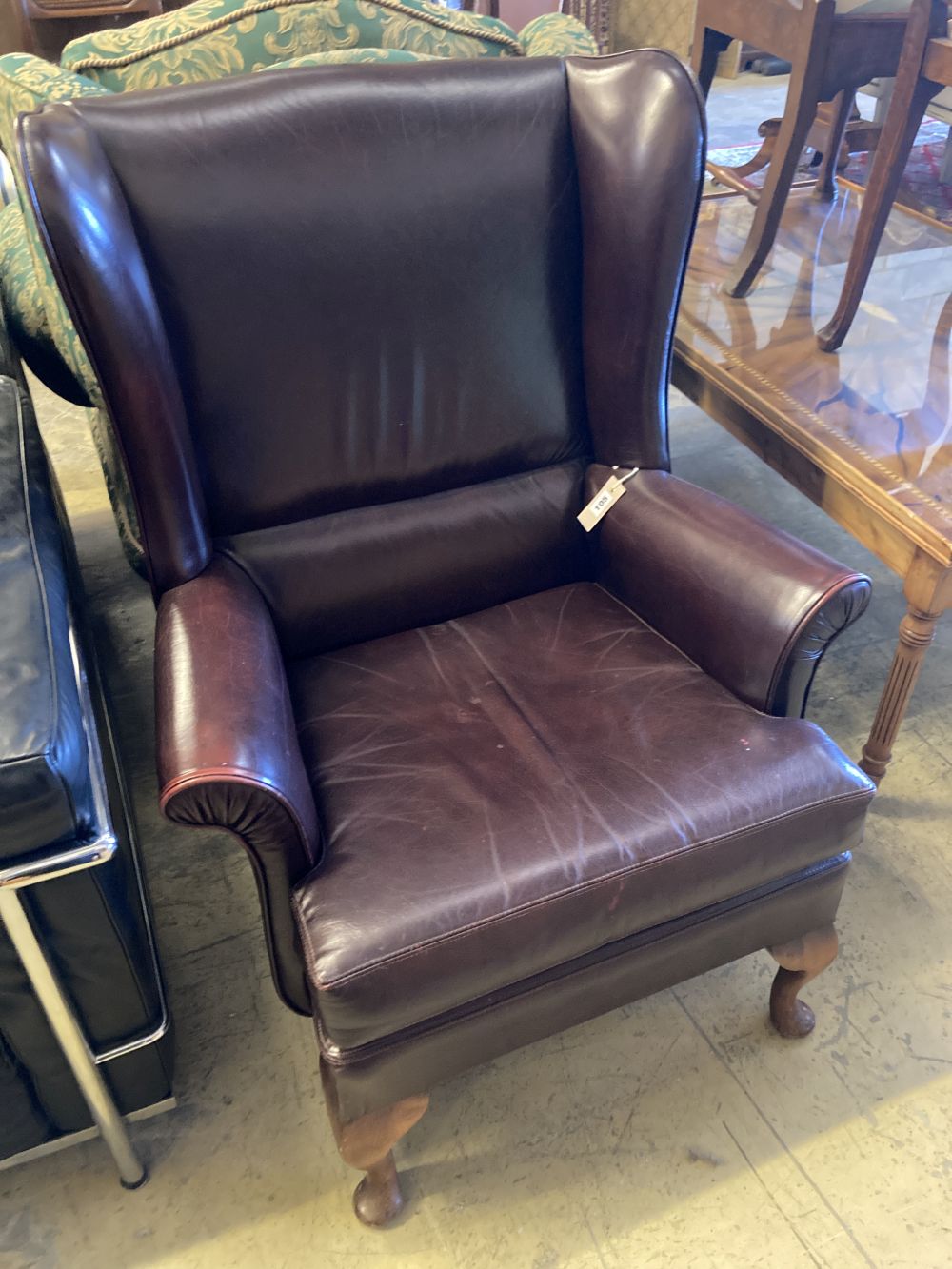 A burgundy leather wing armchair, width 74cm, depth 86cm, height 97cm
